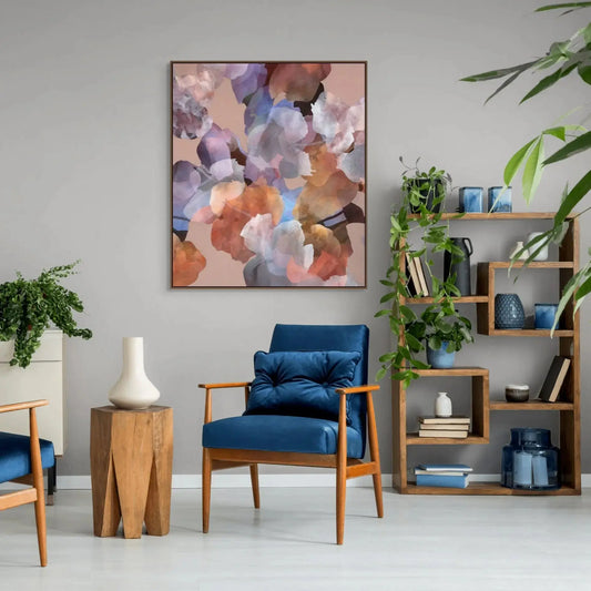 Modern living room with blue chairs, a colorful abstract painting, and bookshelves.