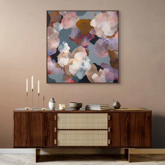 Abstract floral painting on a beige wall above a wooden sideboard.