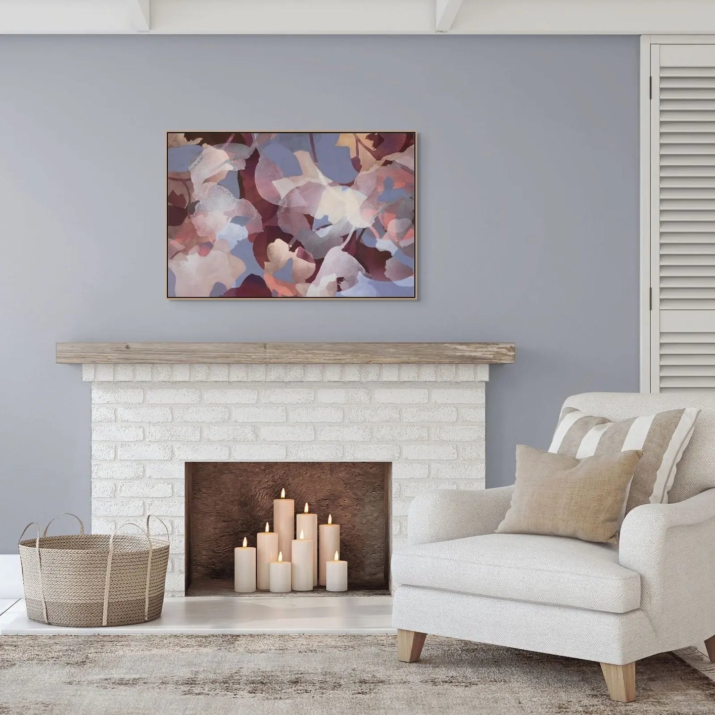 Living room with a fireplace, armchair, and abstract painting on a gray wall.