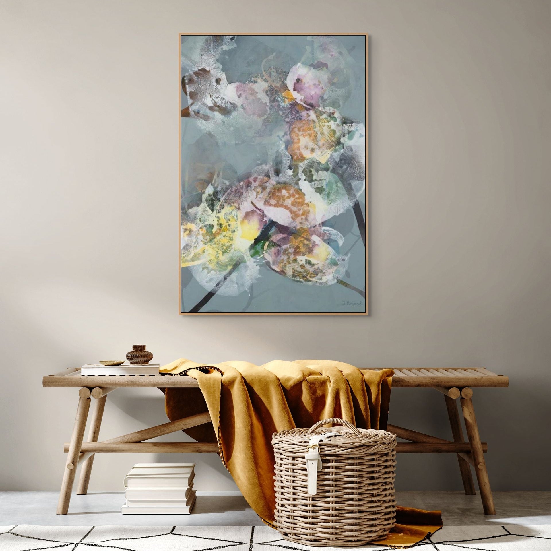Floral artwork on a wall above a wooden bench with a basket and books.