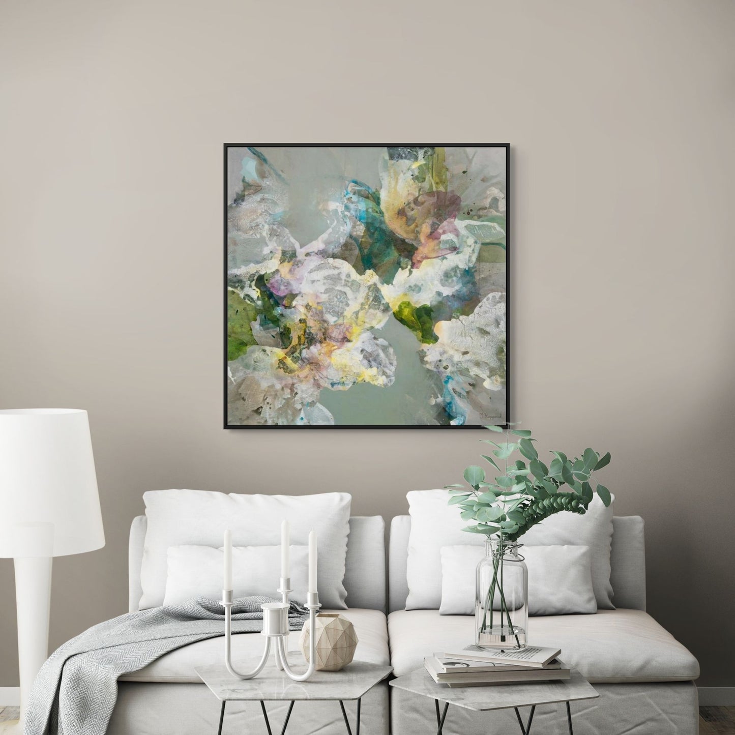Living room with a white sofa, abstract floral painting, and decorative items.