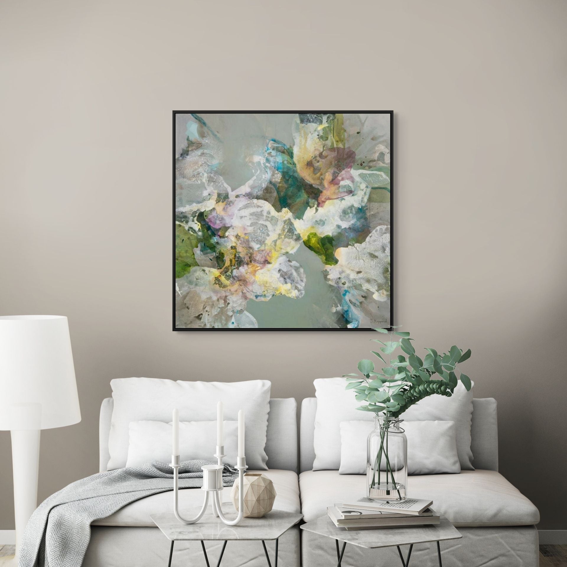 Living room with a white sofa, abstract floral painting, and decorative items.