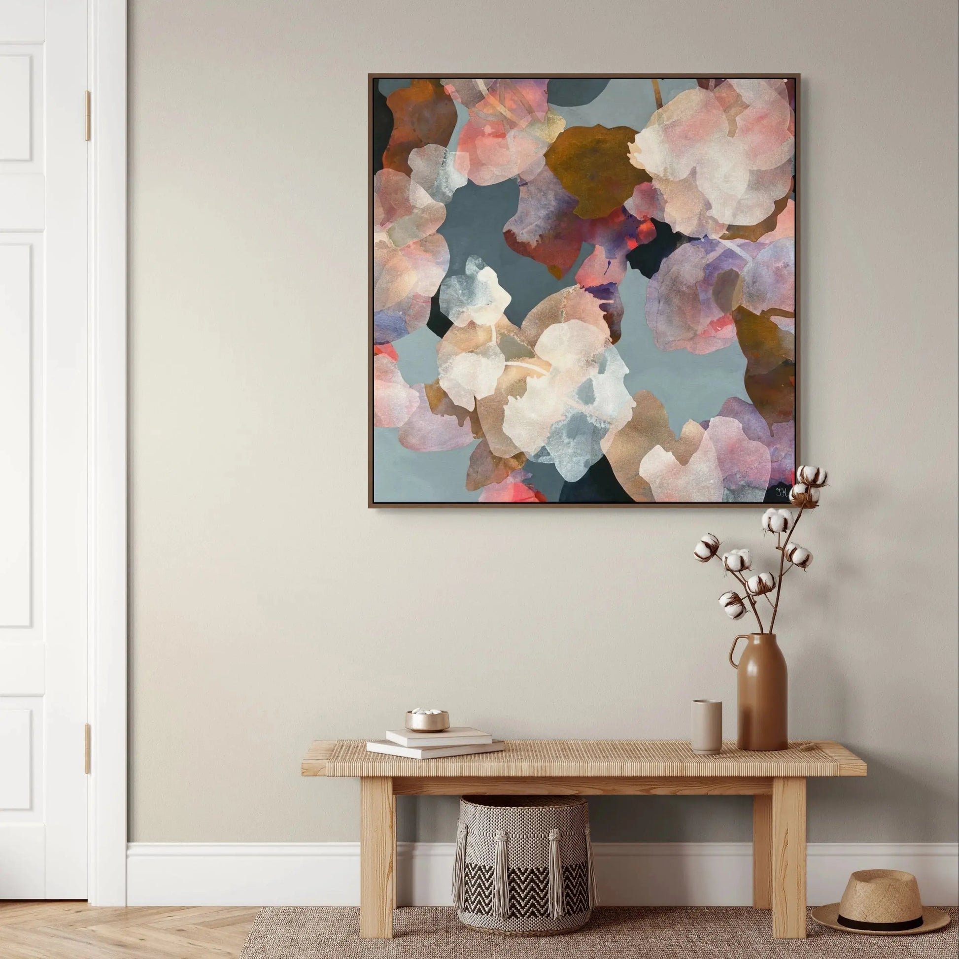 Abstract floral painting on a wall above a wooden bench with decorative items.