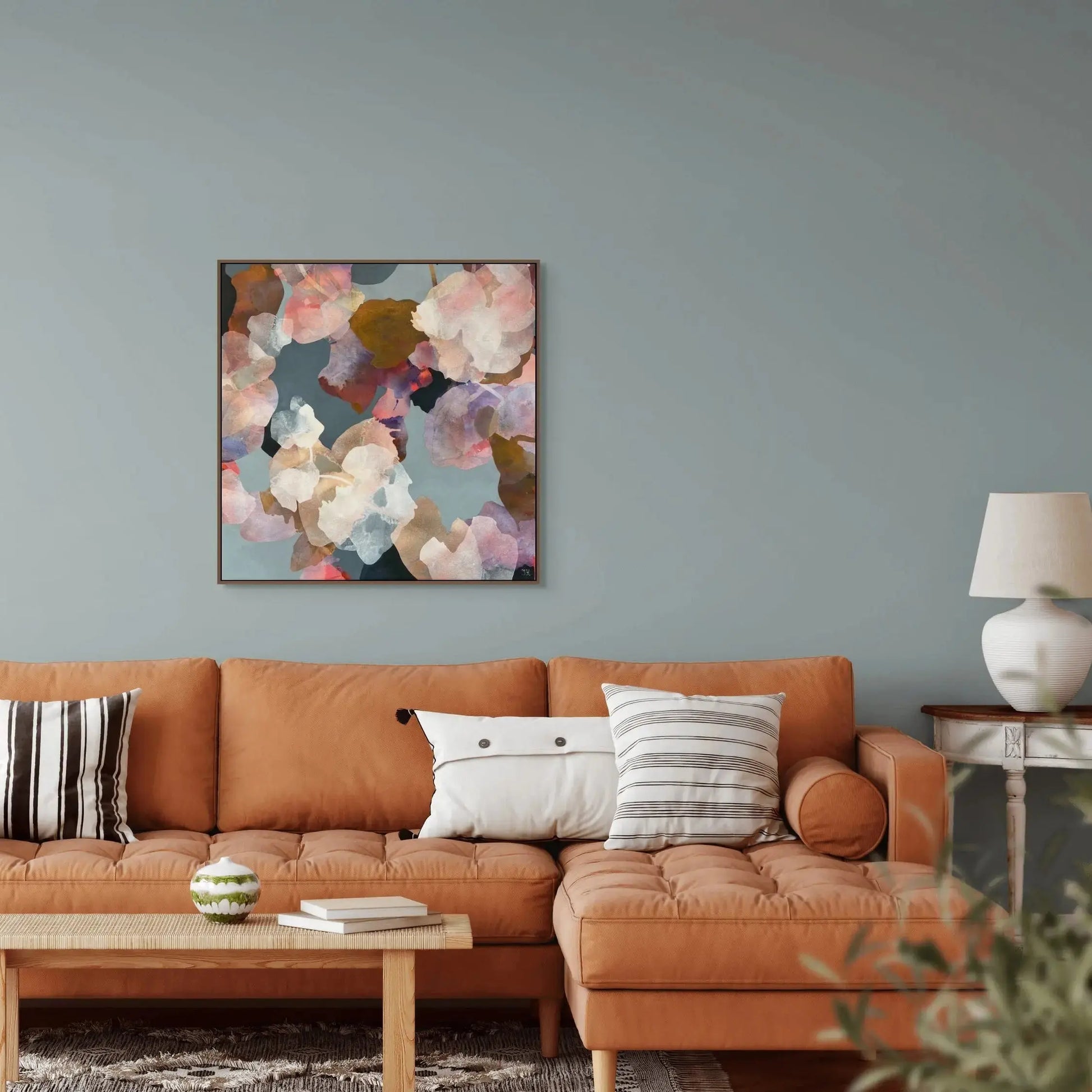 Living room with a brown sofa, coffee table, and abstract floral artwork on the wall.