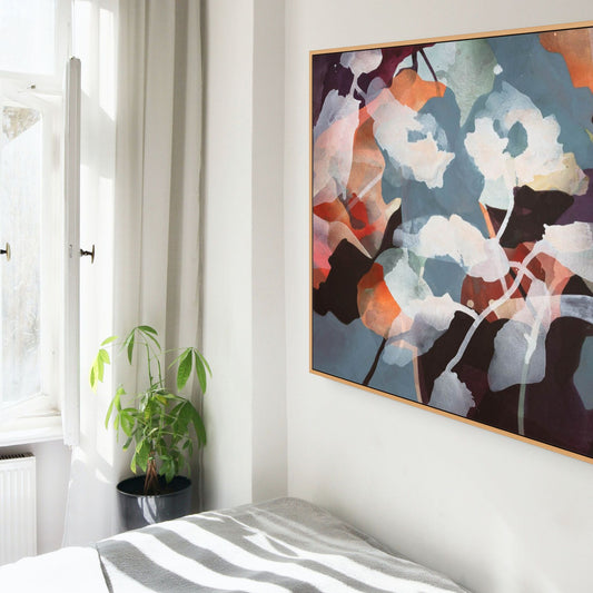 Light bedroom with a large abstract floral painting on the wall.