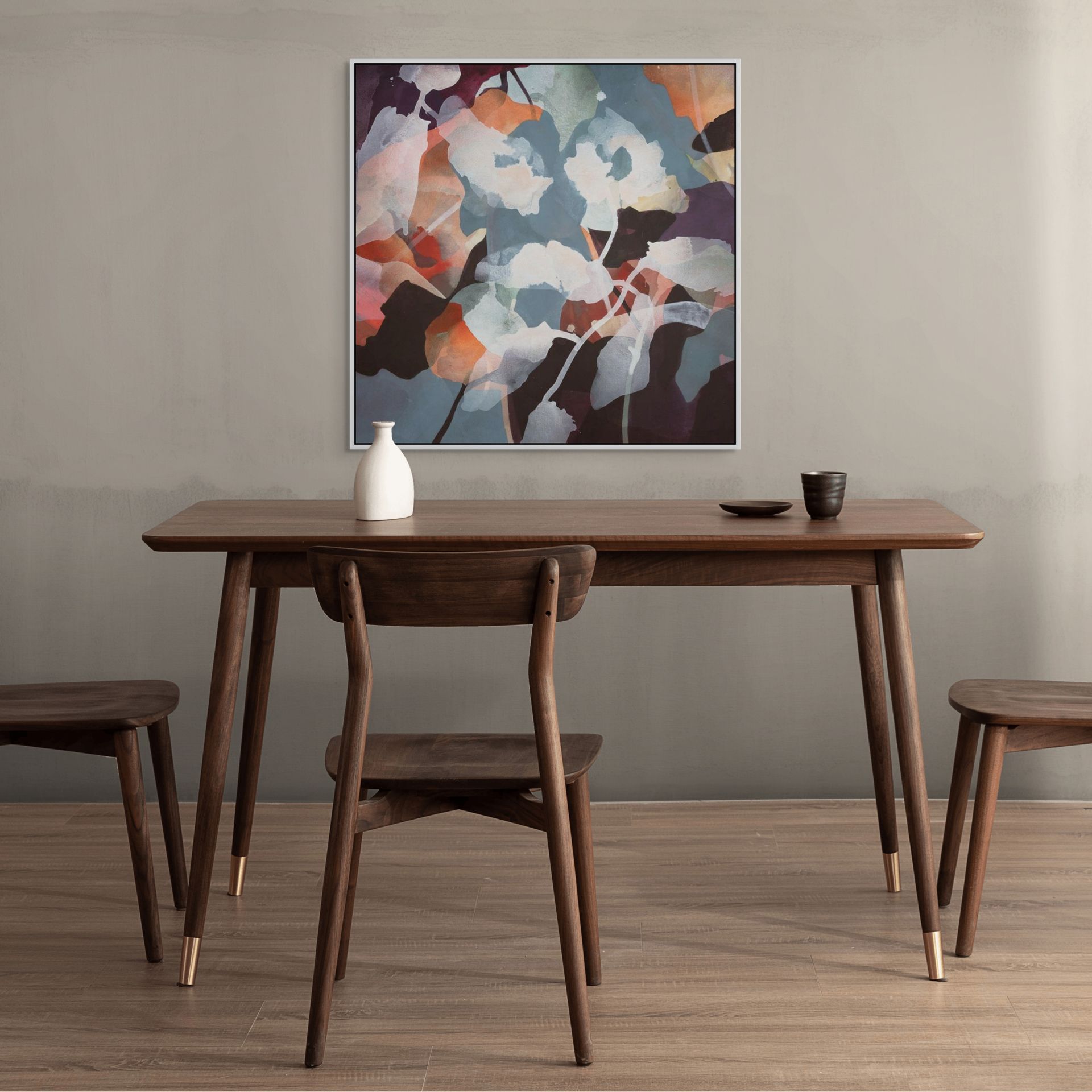 Room with wooden dining table with chairs and abstract floral art on the wall.
